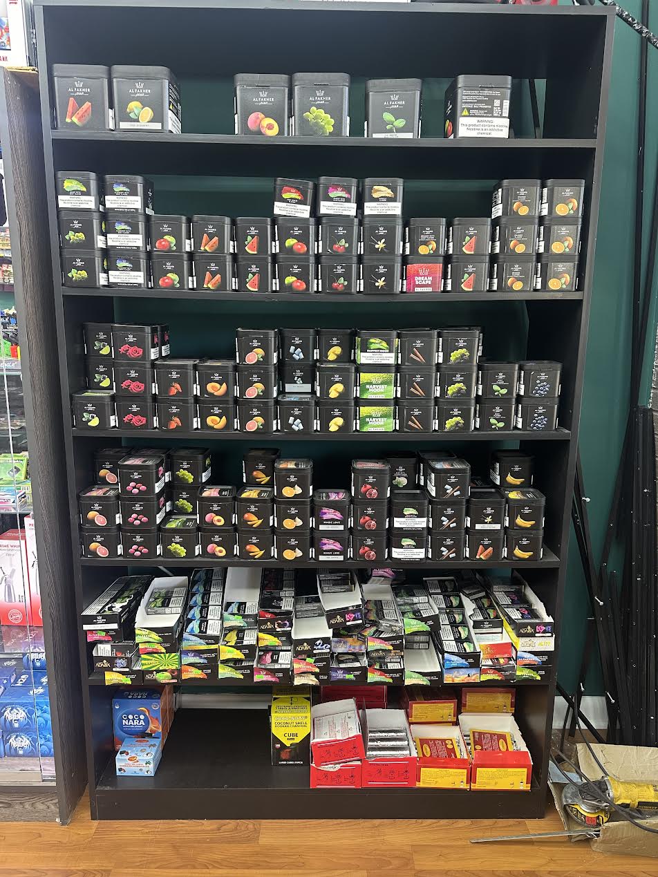 Shelves filled with various flavored Al Fakher hookah tobacco boxes
