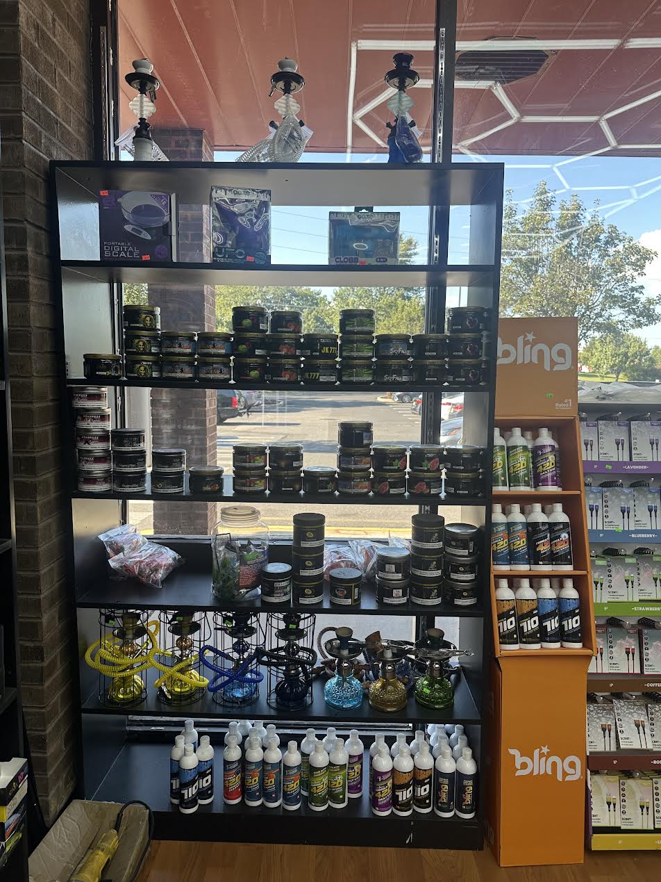 Smoke shop display with hookahs, jars, bottles, and accessories on shelves