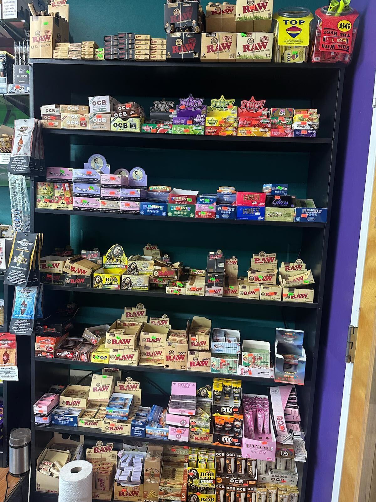 Shelves filled with various rolling papers, smoking accessories, and brands