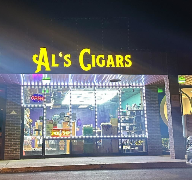 Illuminated Al's Cigars storefront at night with bright open sign
